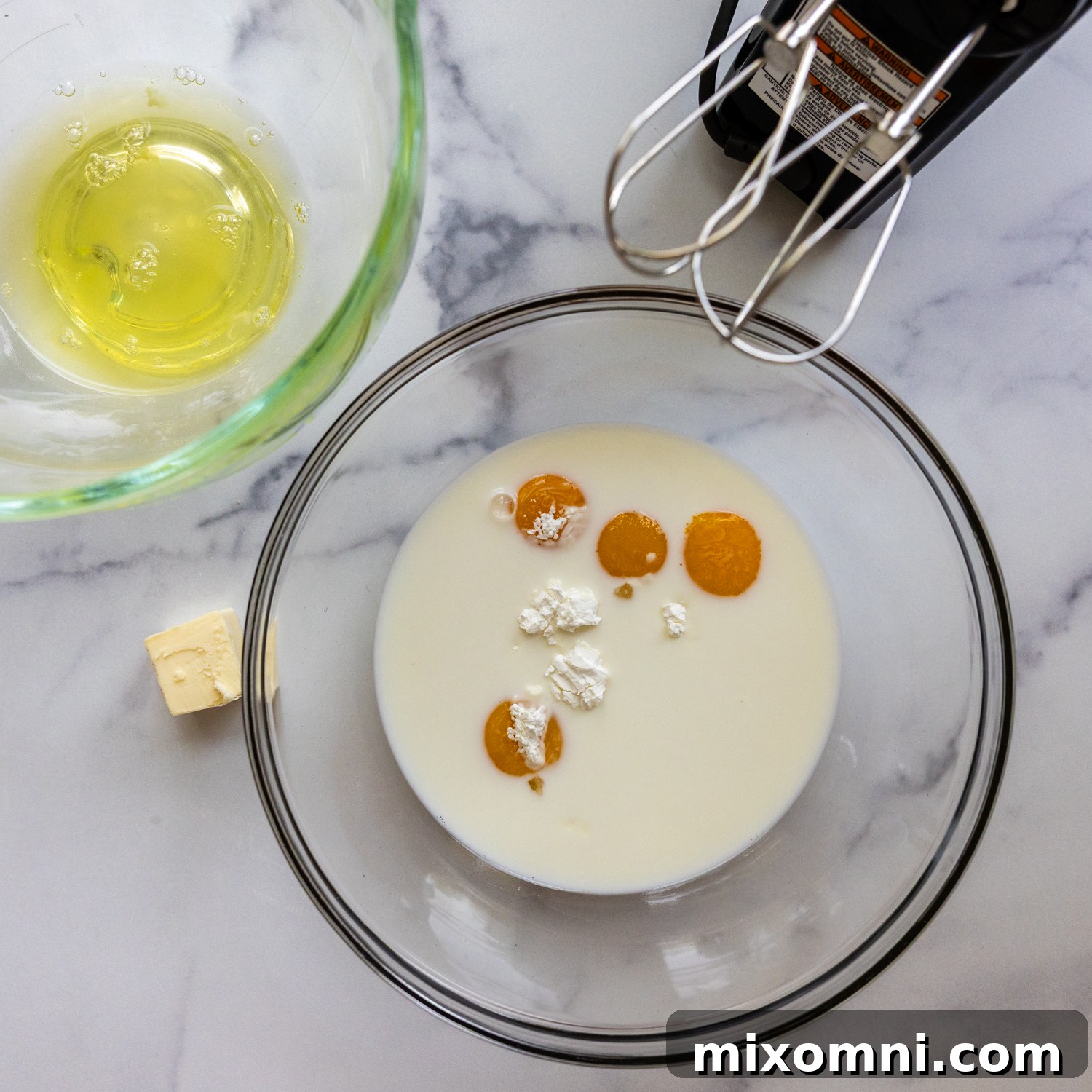 Eggs and cream of tartar in a mixing bowl.
